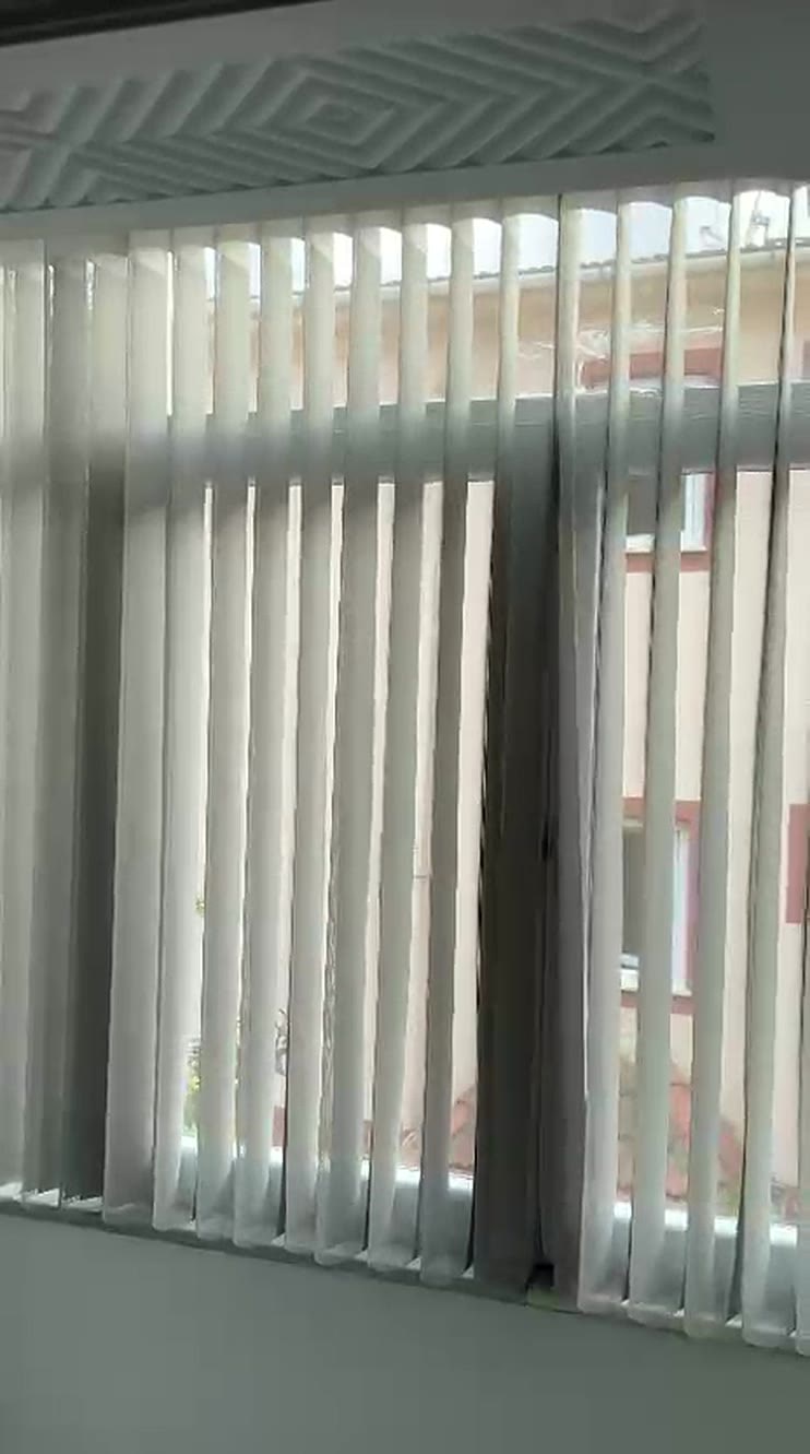 Geniş pencerede beyaz dikey şerit jaluzi